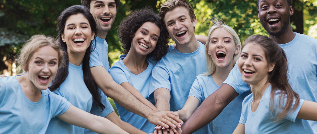 Team of adults with hands in smiling and cheering