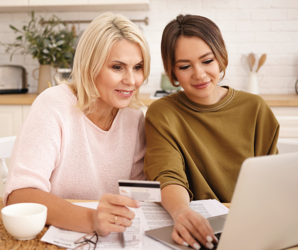 mother and daughter reviewing credit card info on computer