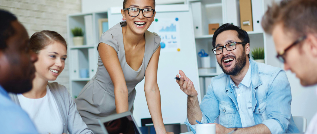 group of young professionals in a meeting laughing