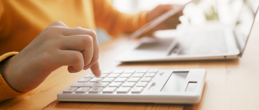 Person using calculator and laptop