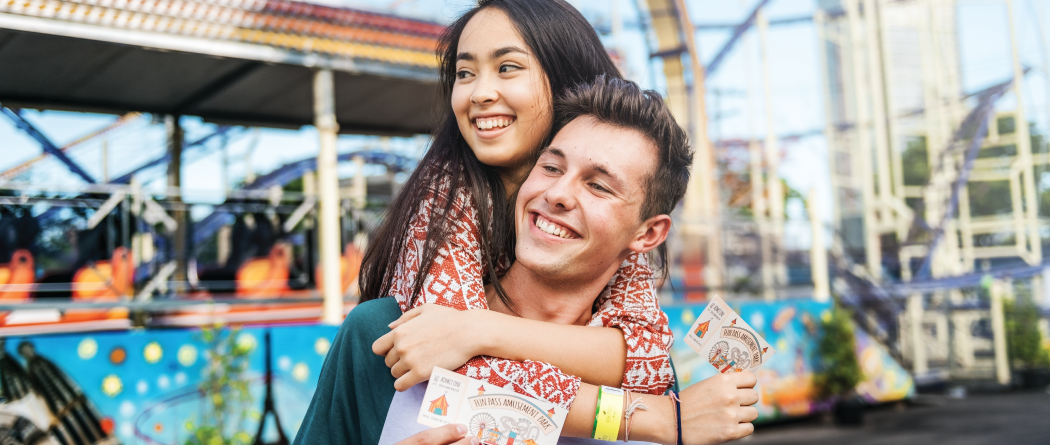 couple hanging out at carnival with carnival tickets in hand