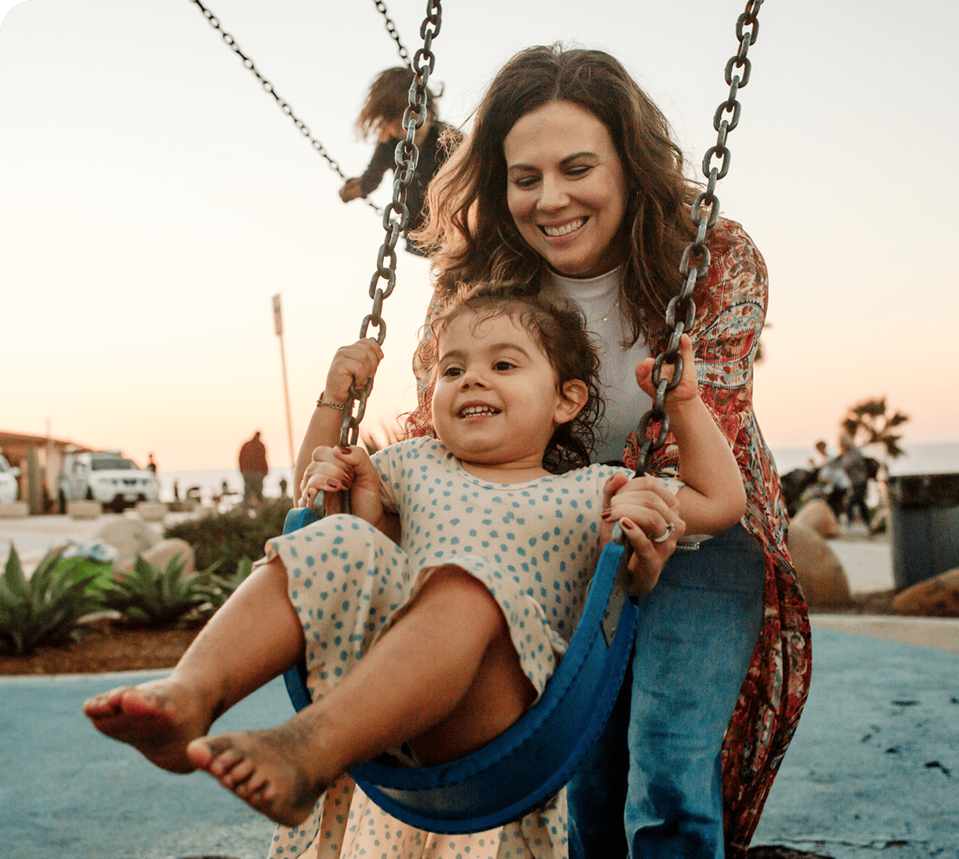 woman pushing her child on a swing